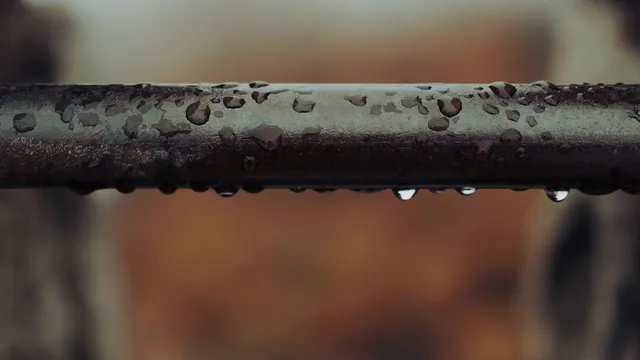Gouttes d'eau sur une canalisation métallique, symbole des fuites cachées